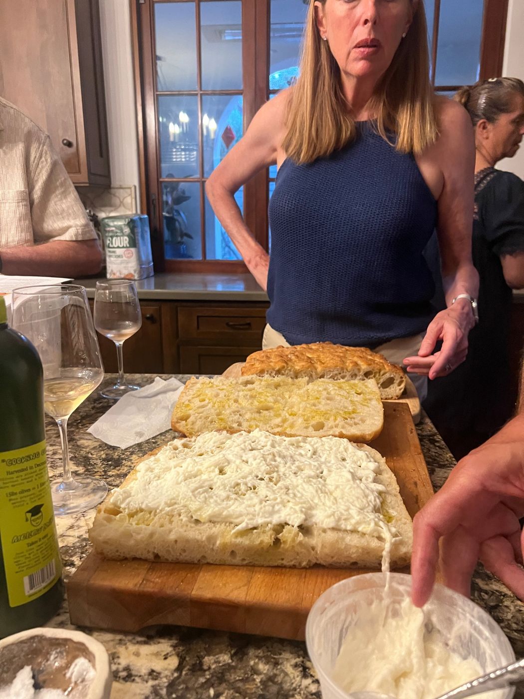 Split focaccia spread with burrata on a cutting board